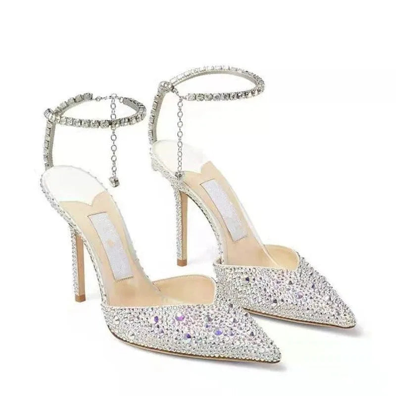 Pair of high-heeled shoes with crystal embellishments on a white background
