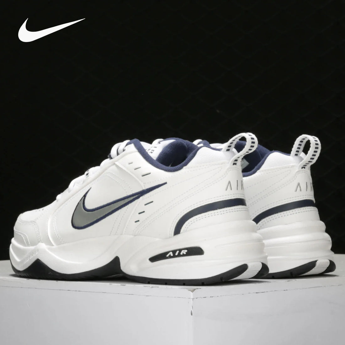 White Nike Air Max sneakers with black swoosh logo on a black background