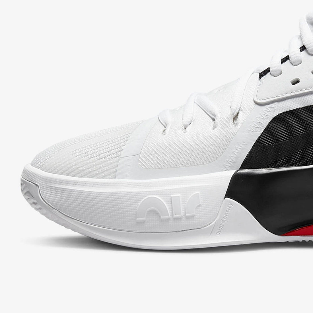 A close-up side view of a white Nike basketball shoe with black accents and a small red detail on the heel, set against a clean white background.