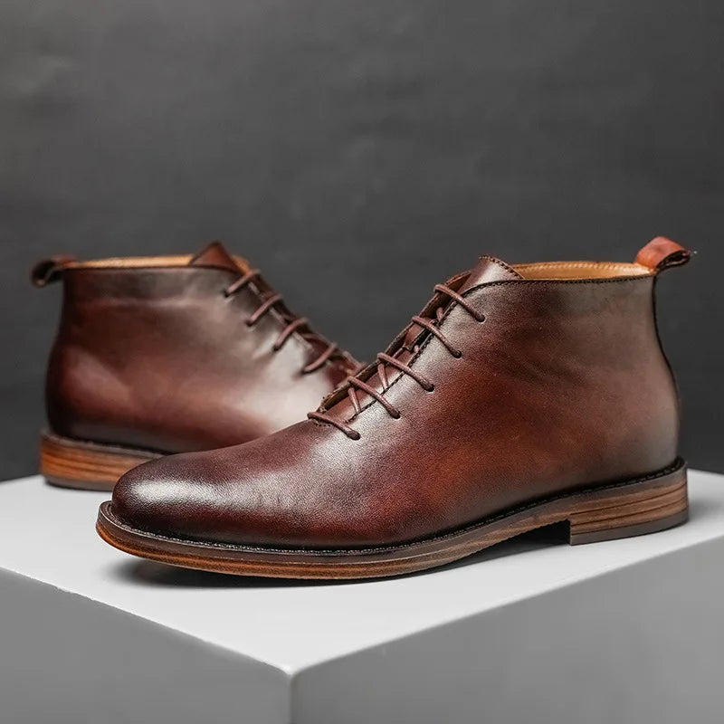 Pair of brown leather boots on a gray background