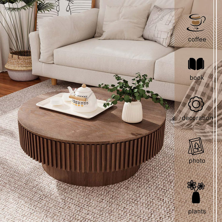 Round wooden coffee table with decorative items in a living room setting