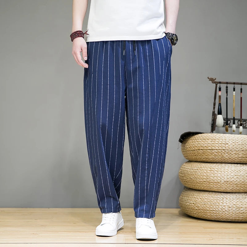 Person wearing blue striped pants with a white shirt in a room setting.